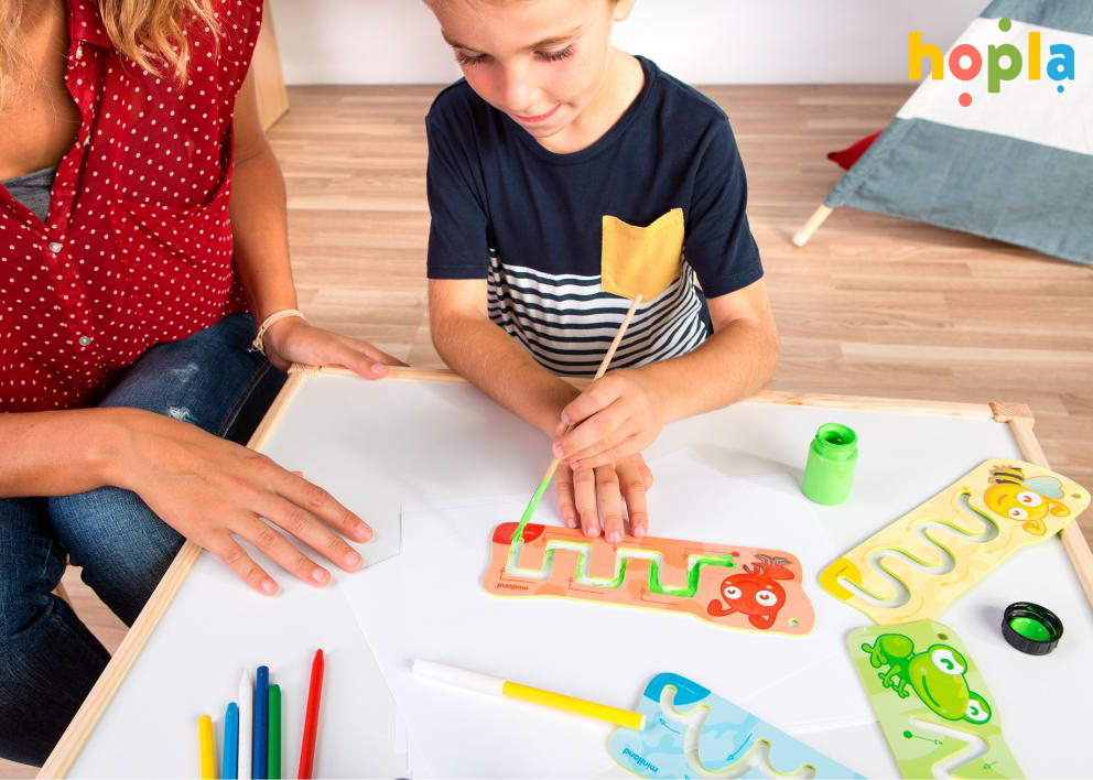Chlapec, ktorý kreslí čiary pomocou šablón na grafomotoriku